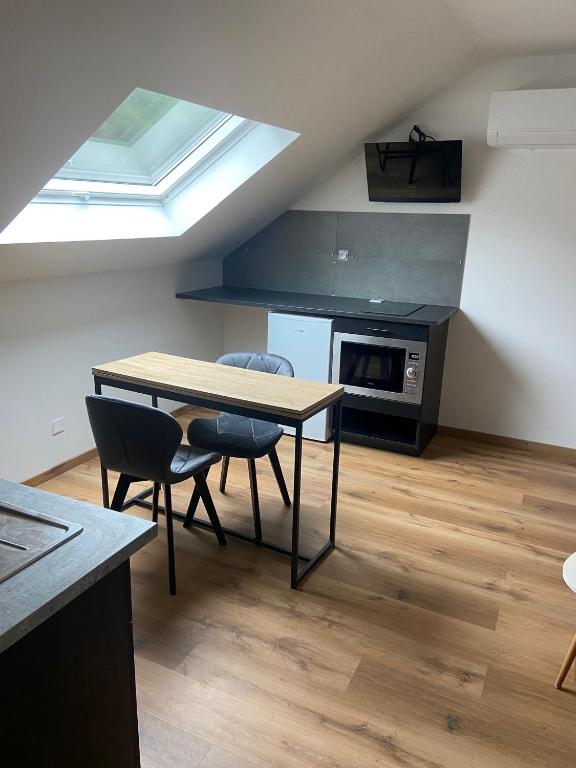a kitchen with a table and chairs in a room at location appartement neuf dans maison in Aix-les-Bains