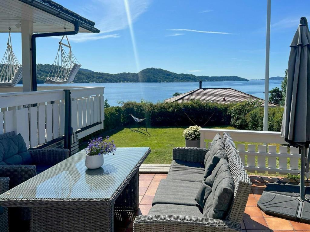 a patio with a table and chairs and a view of the water at Cottage With Private Dock By Eidangerfjord in Porsgrunn