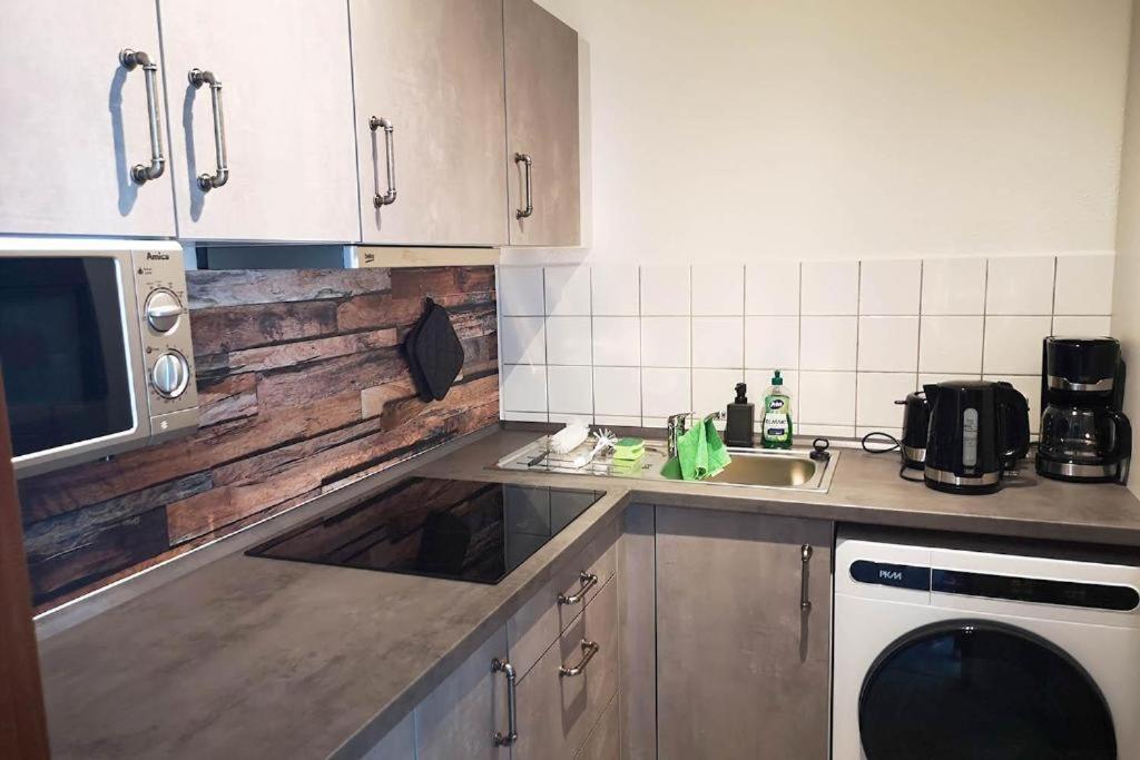 a kitchen with a sink and a microwave at Ferien- & Monteurwohnung, 5 Betten, WLAN, Parkplatz, Balkon in Nonnendorf