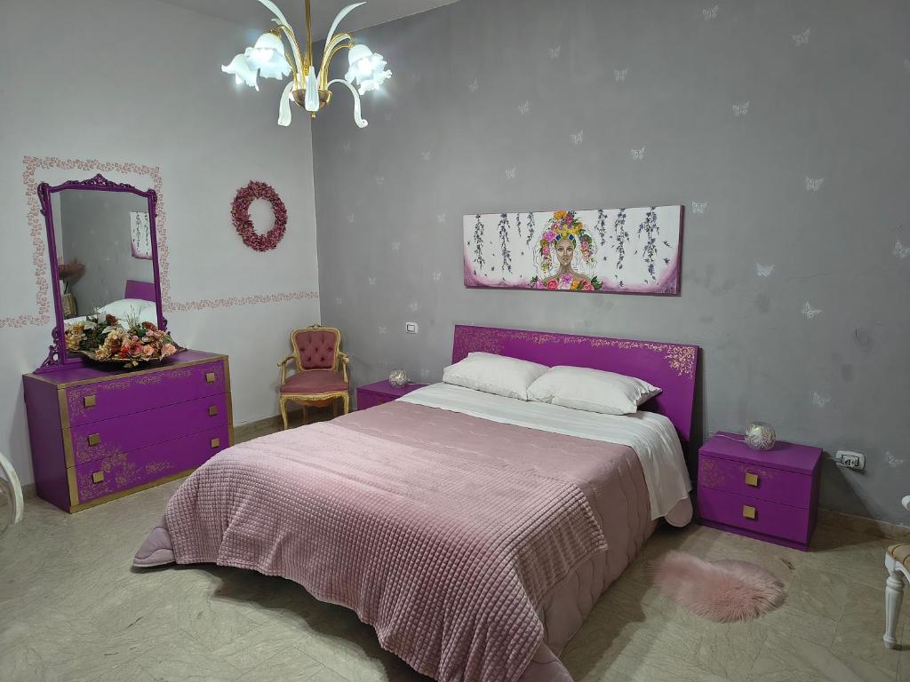 ein Schlafzimmer mit einem lila Bett und einem Spiegel in der Unterkunft Casa Vacanze Ciccinè in Capaci