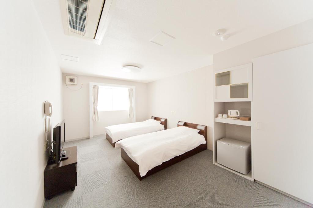 Postel nebo postele na pokoji v ubytování The Shin-Okubo International Hotel
