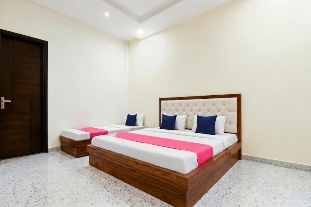 two beds in a room with white walls at Hotel Savera Amritsar Near Golden Temple in Amritsar