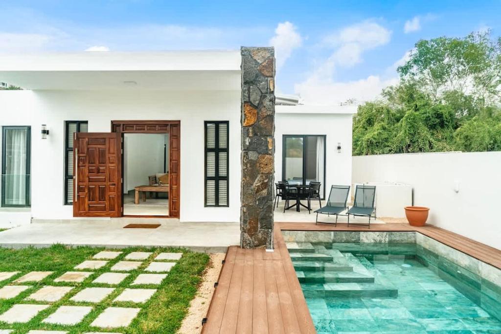 a villa with a swimming pool and a house at Mango House - 2 Bedrooms & Private Pool in La Gaulette