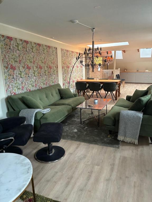 a living room with a green couch and a table at Fiskargränden, Landskrona in Landskrona