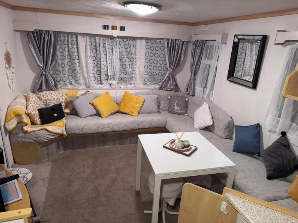 a living room with a couch and a table at Caravan in Chapel Skegness in Chapel Saint Leonards