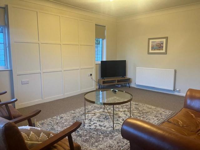 a living room with a couch and a table and a tv at Brocklamont cottage in Ballymena