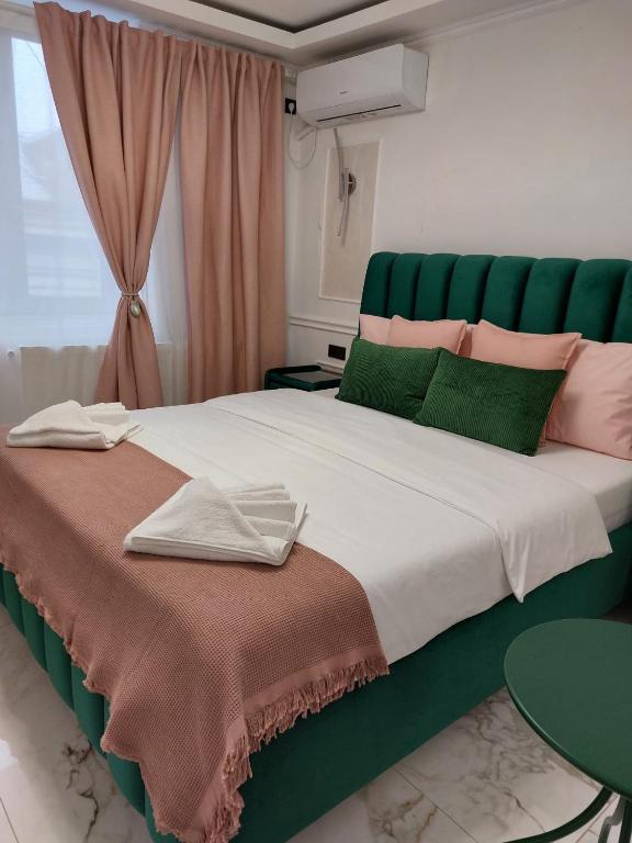 a bedroom with a large bed with a green headboard at studio lipscani Old Town Center in Bucharest