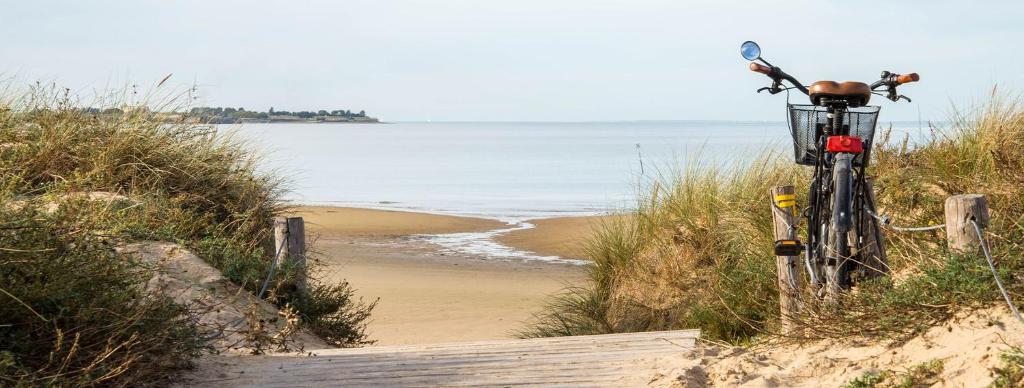 a bike parked on a path to the beach at Camping Le Platin - La Redoute in Rivedoux-Plage