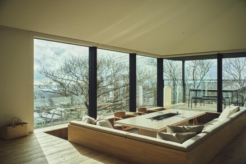 a living room with a large couch and a table at Hiire IZU FUTO in Ito