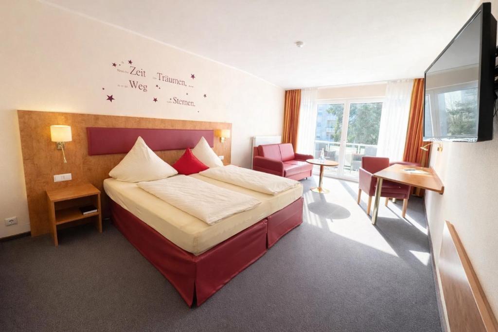 a hotel room with a bed and a chair at Hotel Häfner in Bad Schonborn