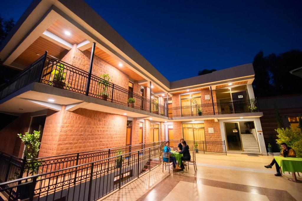 two people standing in front of a house at night at Tabor Hotel Lalibela in Lalibela
