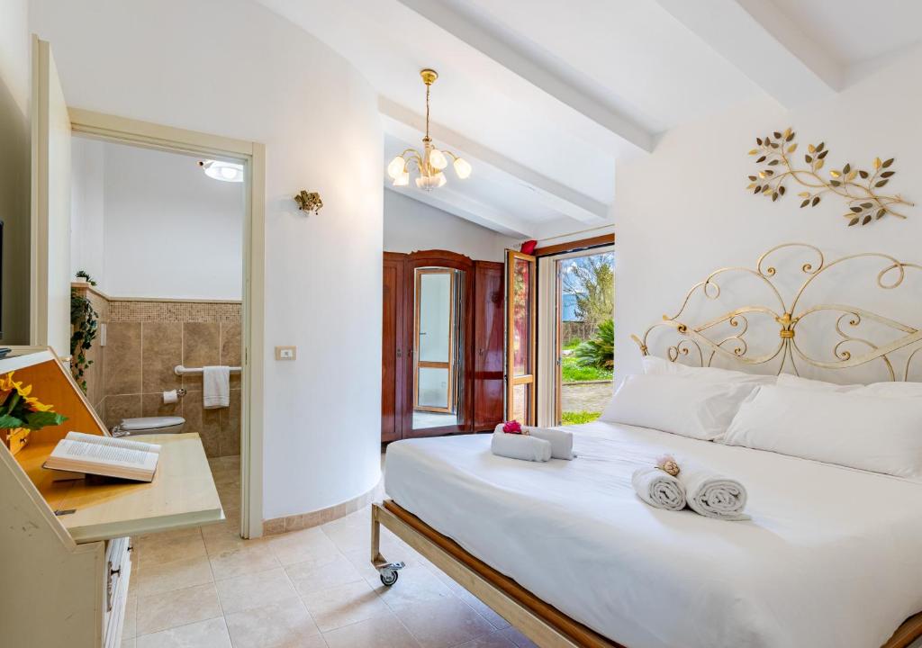 a bedroom with a large white bed and a desk at Hostly G&G Home in Pisa