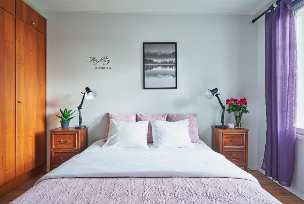 a bedroom with a bed with two dressers and two lamps at Guest House Porvoo in Porvoo