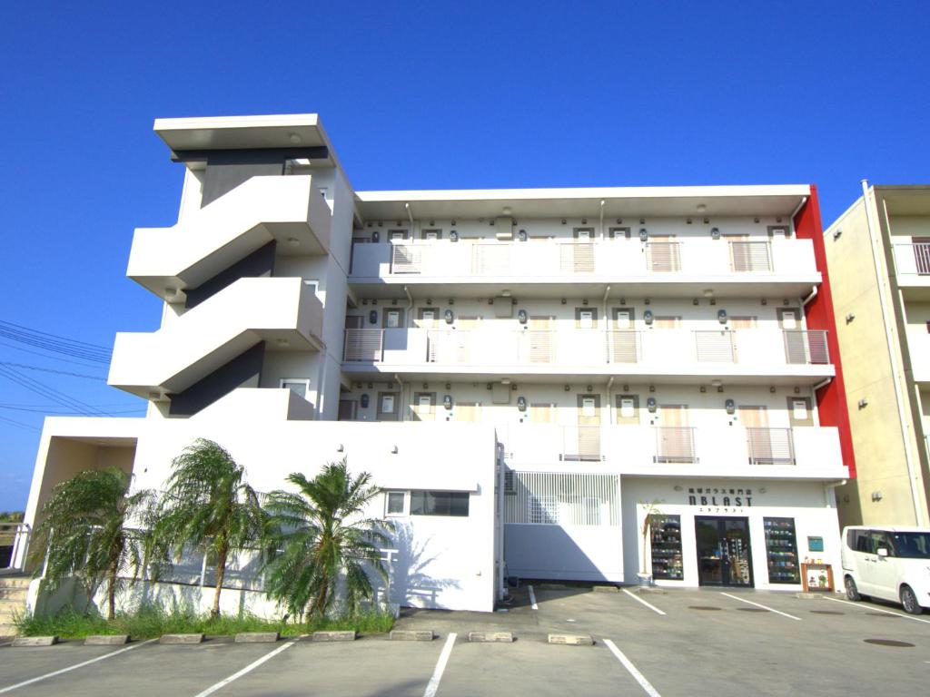 a white building with a parking lot in front of it at コンドミニオ久貝 in Miyako-jima