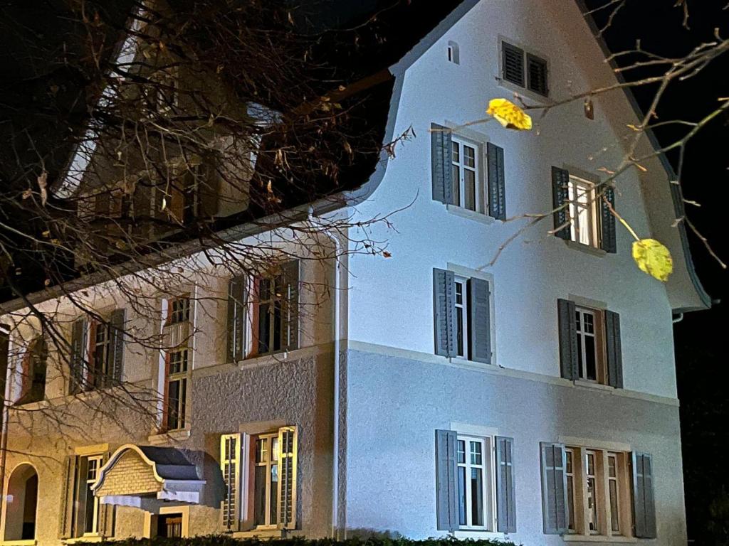 a large white building with windows and doors at night at 1 bed flat in central Zug in Zug