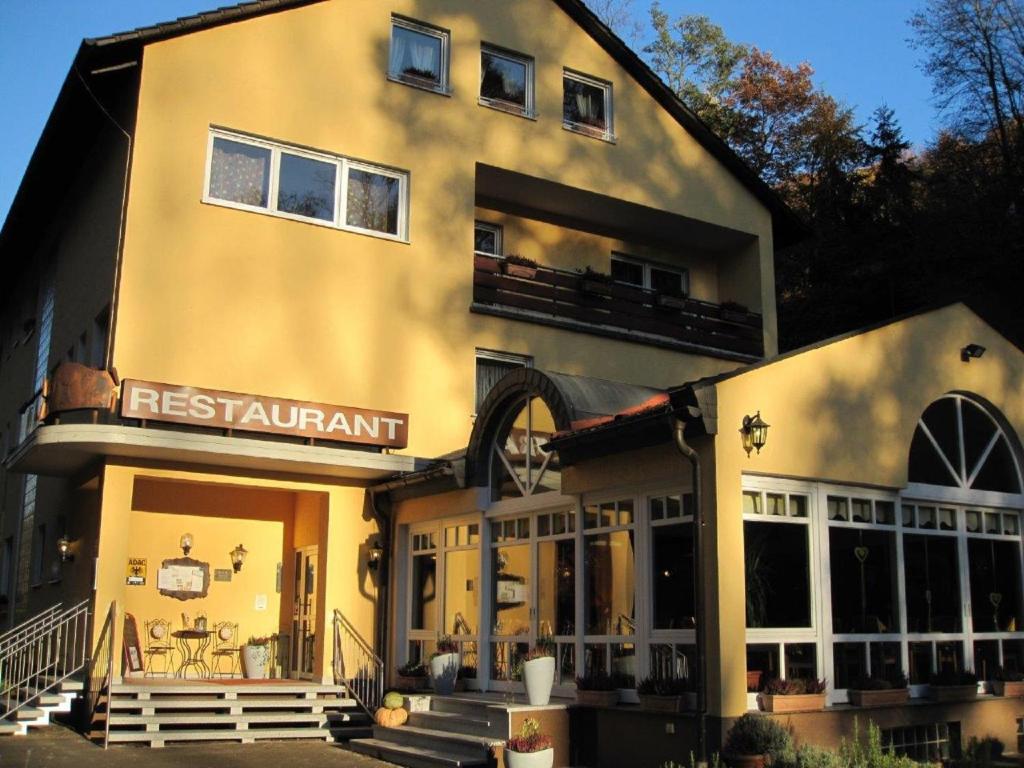 ein großes gelbes Gebäude mit Restaurant-Schild drauf in der Unterkunft Hotel Goldbächel in Wachenheim an der Weinstraße