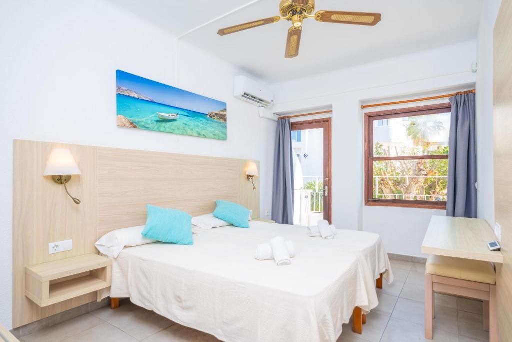 a bedroom with two beds and a window at Hotel Antares in Cala d´Or
