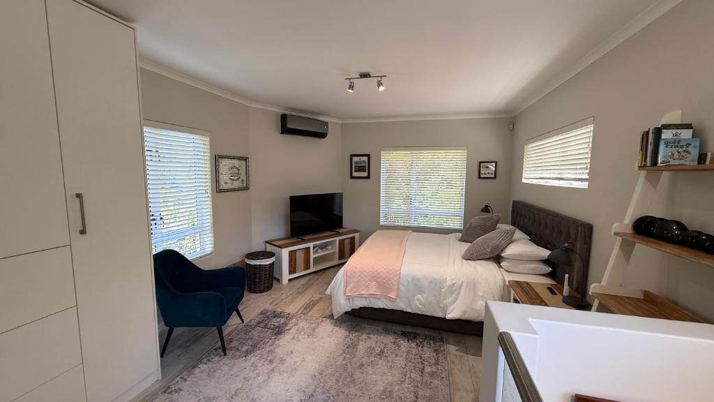 a bedroom with a bed and a desk and a television at Hack's Shack in Cape Town