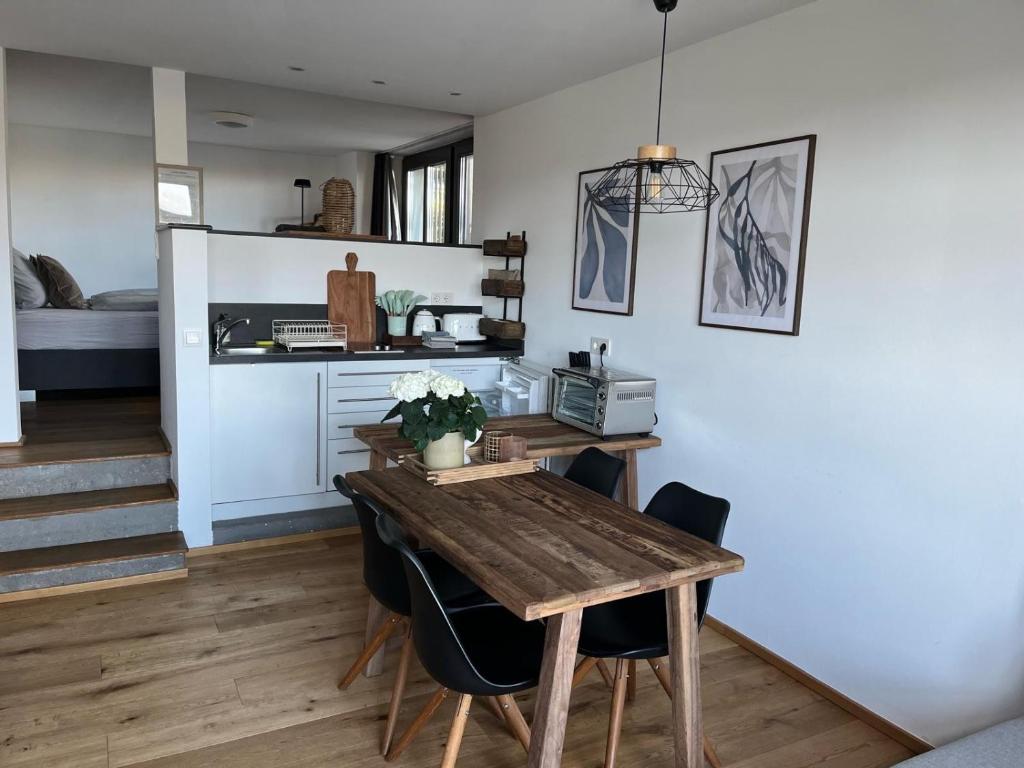a kitchen and dining room with a wooden table and chairs at Seeliebe-Reichenau in Reichenau