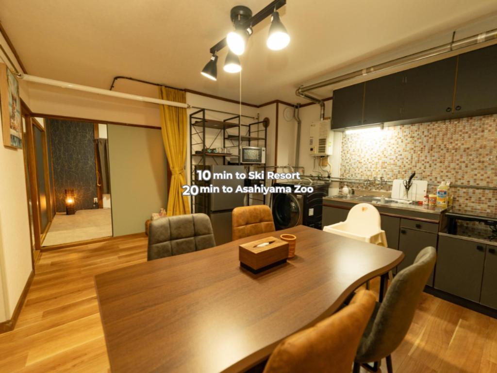 a kitchen and dining room with a table and chairs at BUDDY HOUSE - Newコスパ重視! サンタプレゼントパーク10分! カムイリンクス28分! コンビニ徒歩3分! 旭川鷹栖インター5分! 商業施設すぐ! in Asahikawa