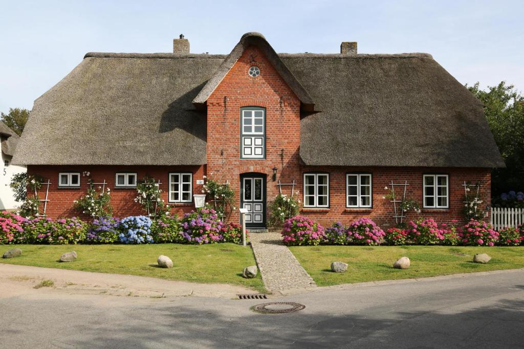 a large red brick house with a thatched roof at Ilskes Hus in Oevenum