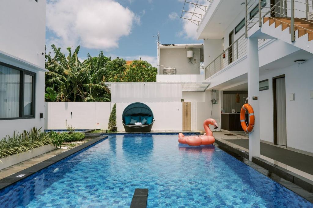 a swimming pool in a house with a pool toy at Domu Alba Vita in Denpasar