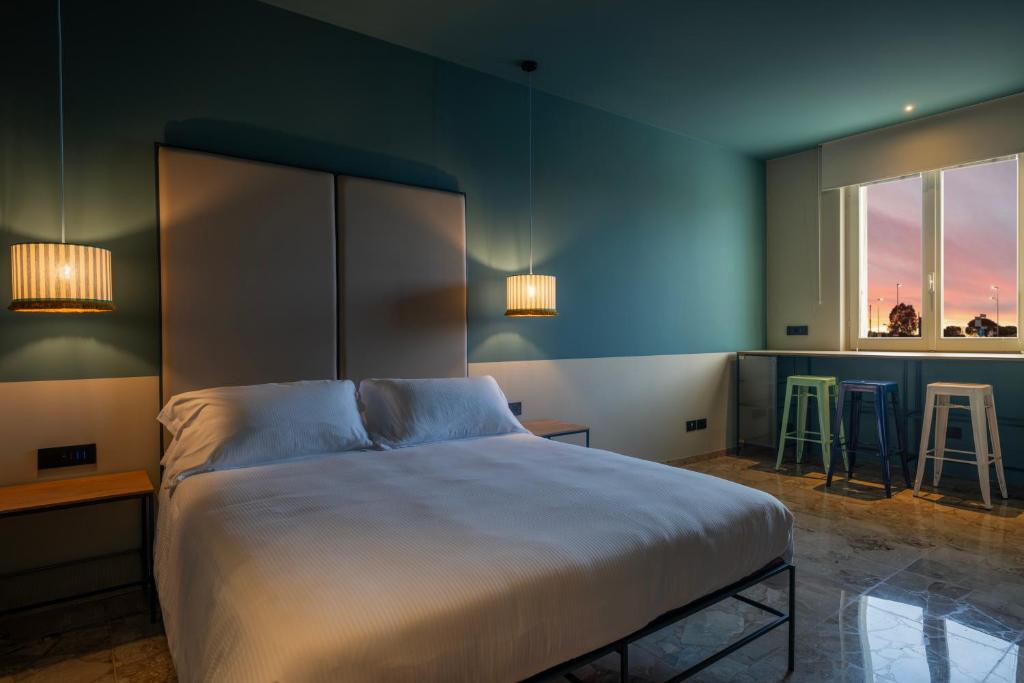 a bedroom with a bed with two stools and two windows at Le Stanze Di Vittoria in Cesenatico