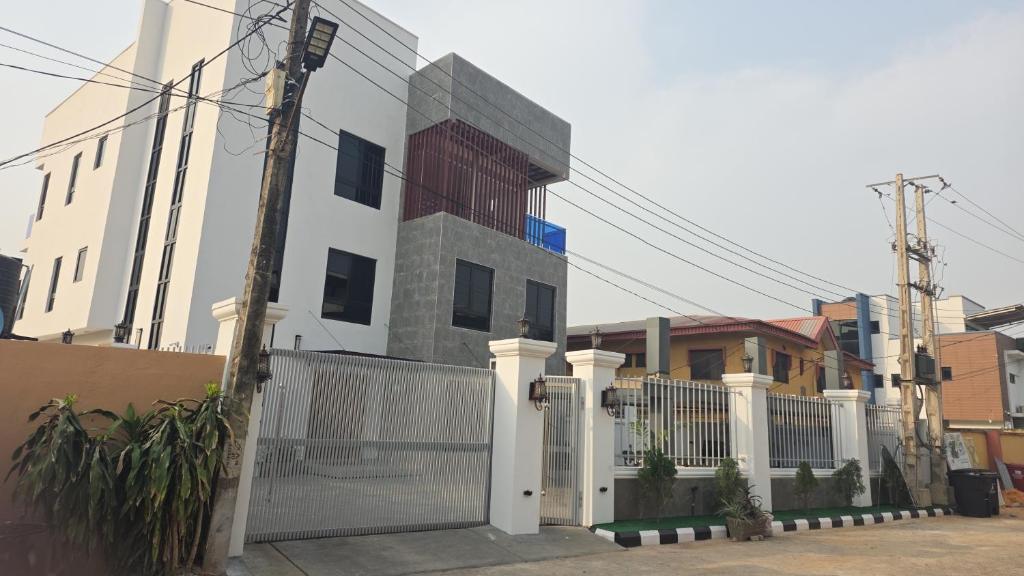 a white house with a gate and a fence at BJ Home in Iseri-Oke