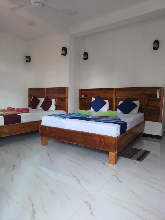 two beds in a room with two bedsvisor at New planet guest in Mirissa