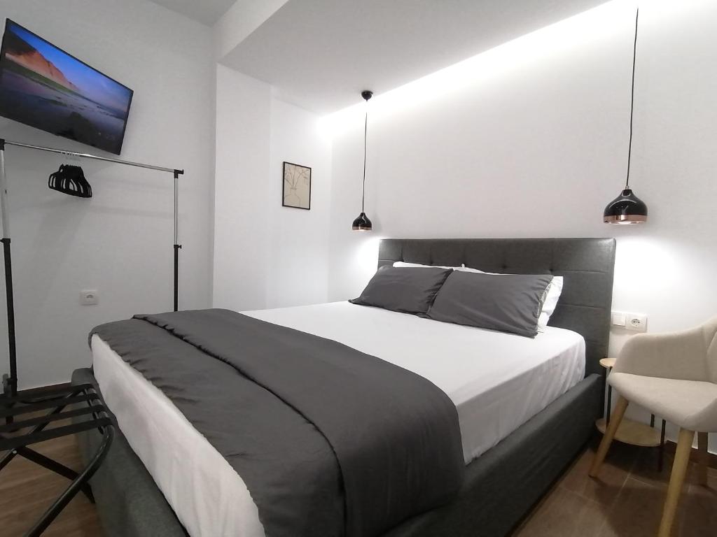 a bedroom with a large bed and a tv at Sfendamos Residence Kavala in Kavála