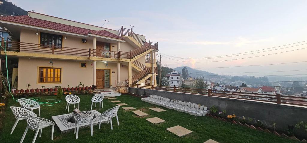 a yard with chairs and a house at Mellowlux Ooty in Ooty