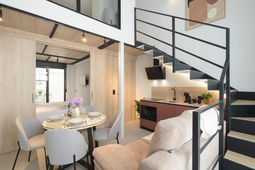 a living room and dining room with a staircase in a house at Apartamentos Nevada Metro con PARKING GRATIS in Maracena