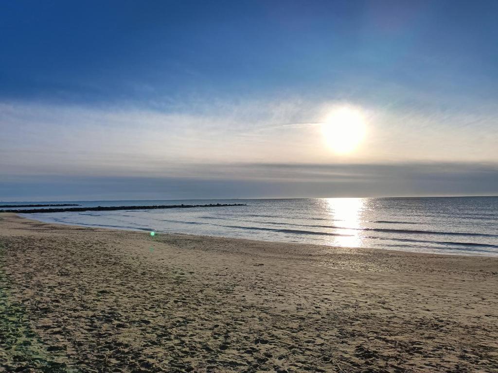 a beach with the sun rising over the ocean at Beach 50 m , vue mer in Carnon-Plage