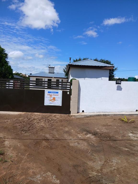a fence with a sign on it next to a building at Efkay Guest in Thohoyandou