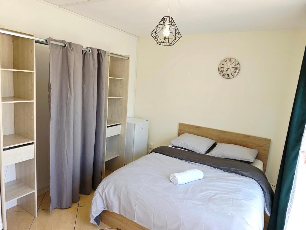 a bedroom with a bed and shelves and a clock at Chambre B1 in Toulouse