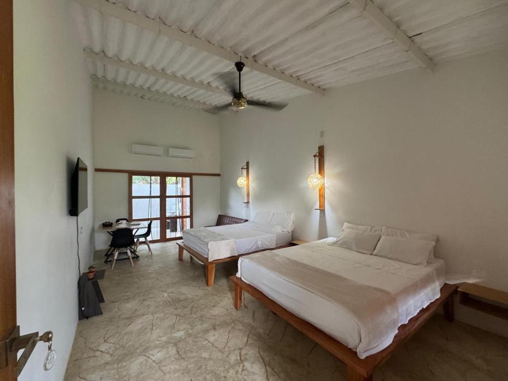 a bedroom with two beds and a television in it at Cabañas Casa Fany in Palomino
