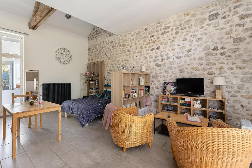 a living room with a couch and a tv at Gîte L'ancien Préau in Avrillé-les-Ponceaux