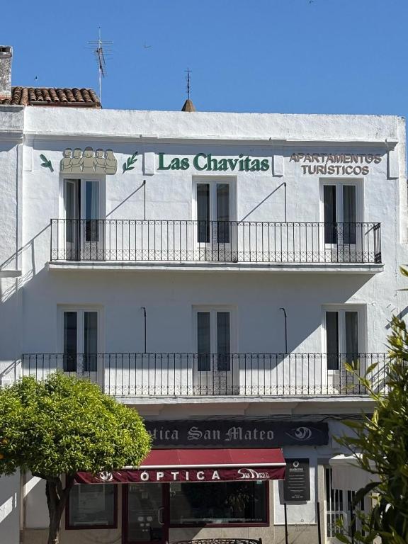 a white building with a sign on the side of it at Las Chavitas Rural Apartamentos turísticos in Alburquerque