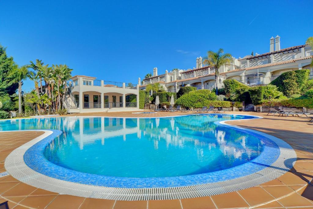 a swimming pool in front of a large building at Villa Magnolia The Crest 3 quartos e piscina in Almancil