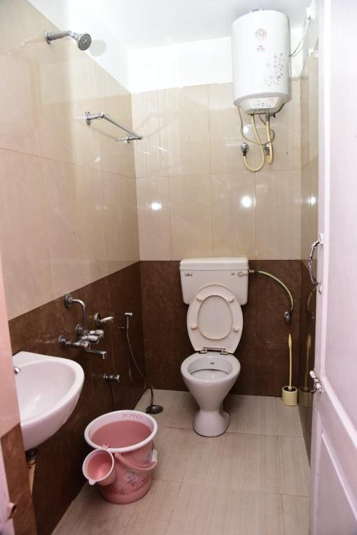 a small bathroom with a toilet and a sink at FFF Cottage in Ooty