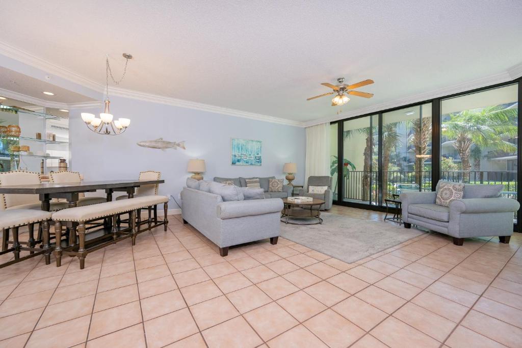 a living room with a table and chairs and a dining room at Phoenix on the Bay 1122 condo in Orange Beach