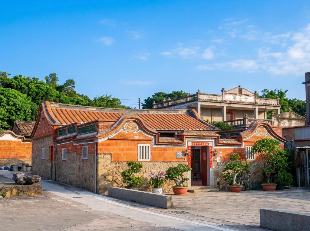 an old brick building with a red door at Zhong Lan Homestay in Chung-lan