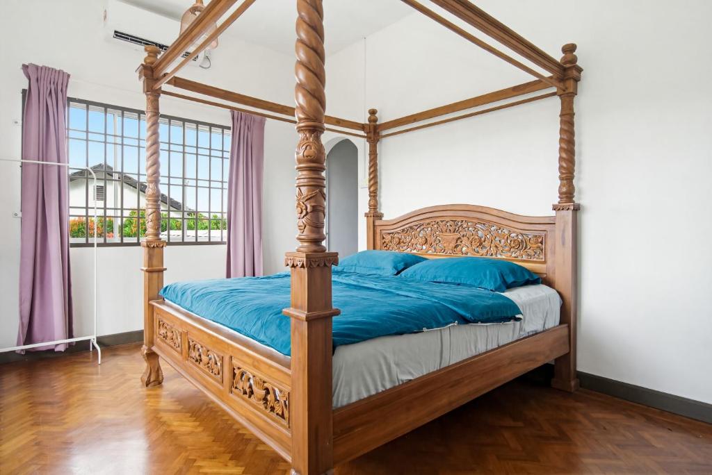 a bedroom with a canopy bed with blue pillows at Ruum1 Sugars Houz in Johor Bahru