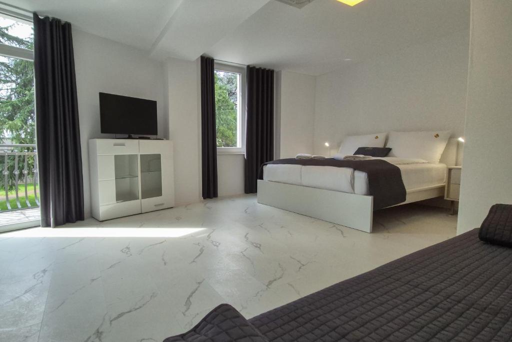 a bedroom with a bed and a flat screen tv at Stopa Art Residence in Šempeter pri Gorici