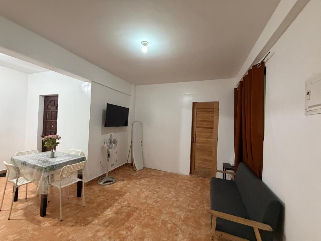 a living room with a table and a television at Paradise Beach Apartment in Boracay