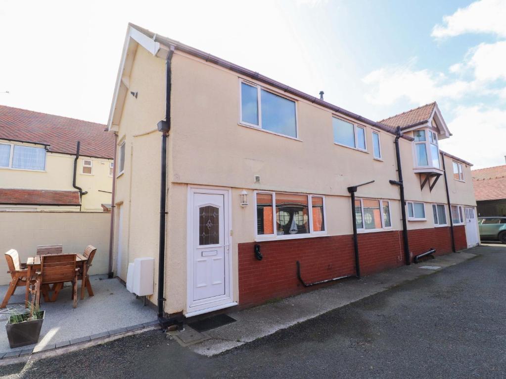 a house with a white door and a table at The Old Stables in Colwyn Bay