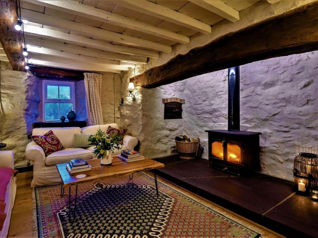 a living room with a fireplace in a stone wall at 3 Bed in Tyn Y Groes oc-80476 in Caerhûn