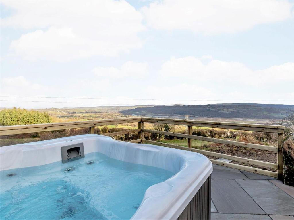 a hot tub on a patio with a view at 3 Bed in Conwy oc-85844 in Llanbedr-y-cennin