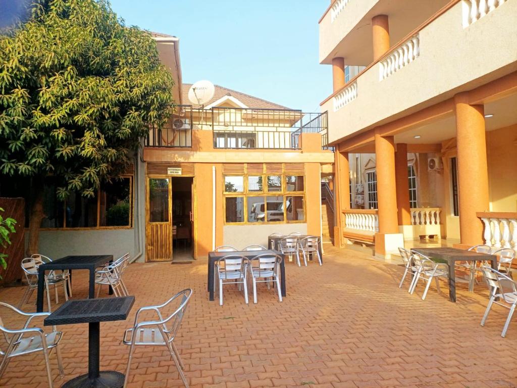 a patio with tables and chairs in front of a building at SARAB HOTEL Wau in Juba