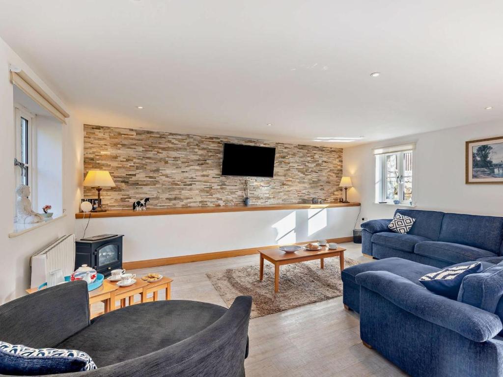 a living room with two blue couches and a fireplace at 2 Bed in Arthog oc-43105 in Arthog